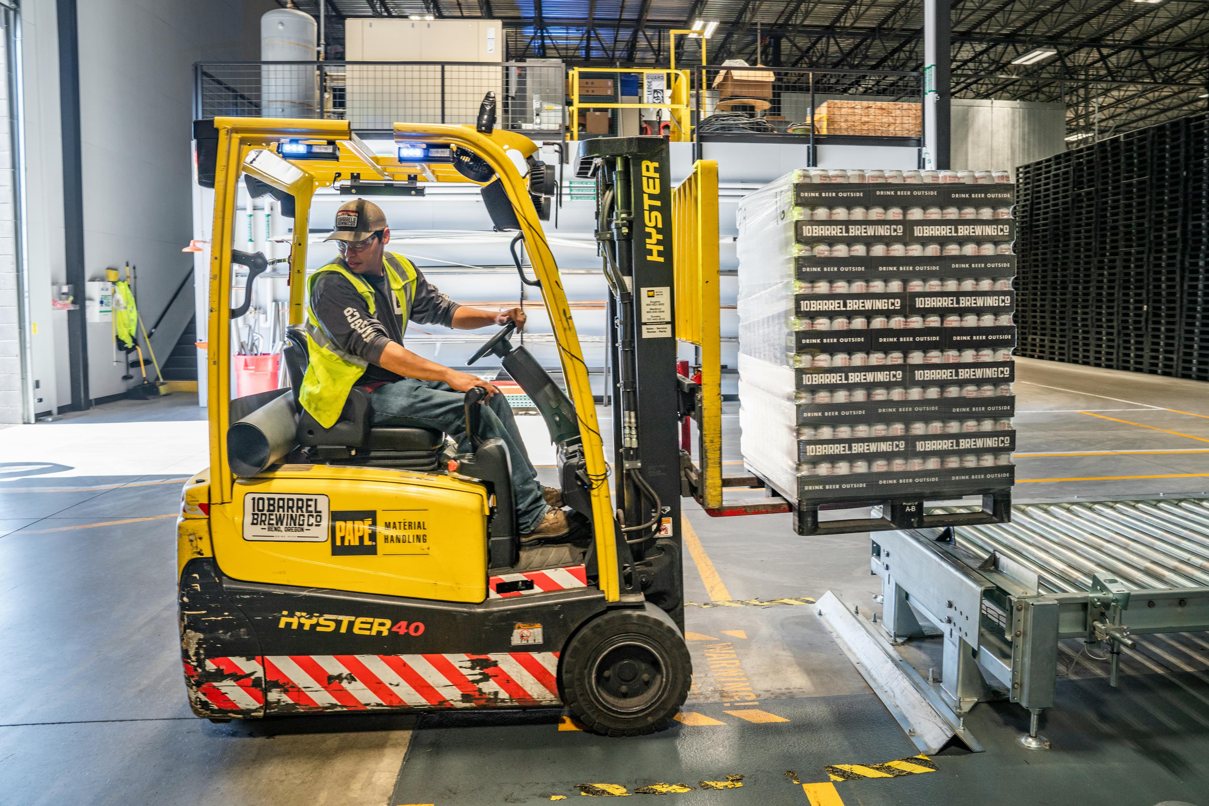 A forklift moving pallets of parcels in a warehouse