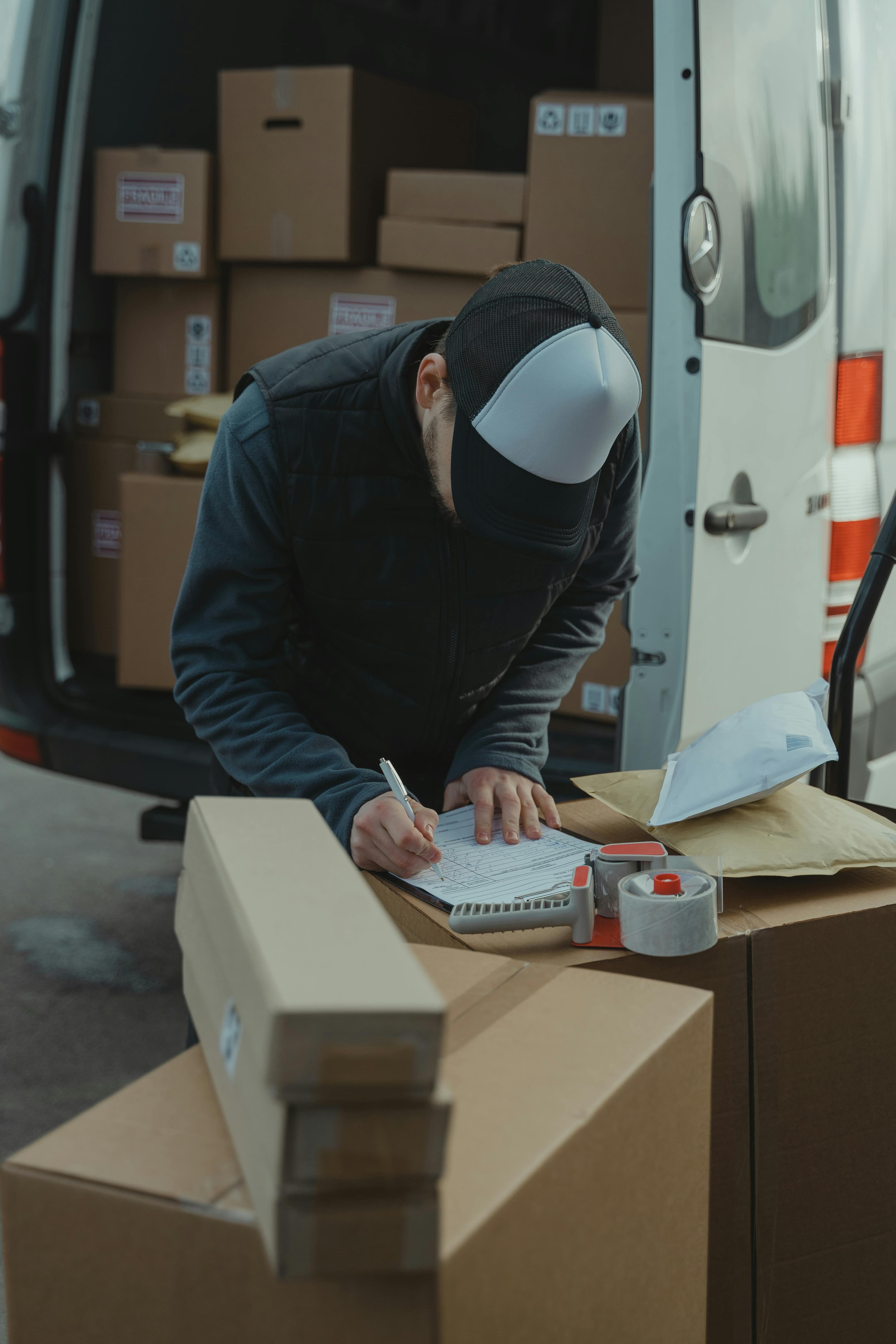 A courier collecting a parcel from a van